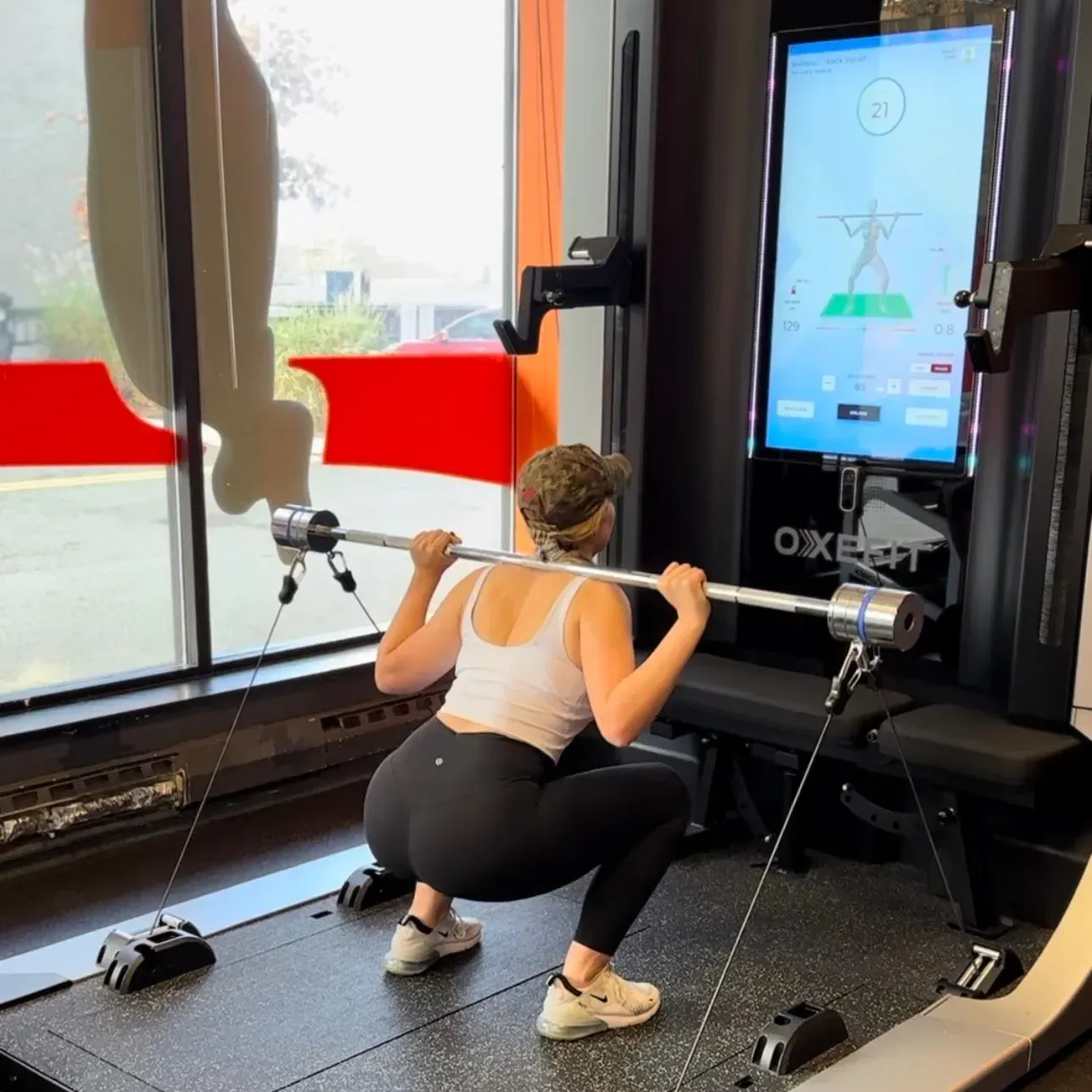 Client squatting on the OxeFit digital resistance system